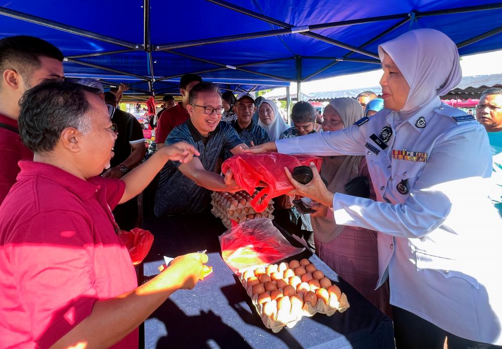 Pengarah Lembaga Pertubuhan Peladang (LPP) Kelantan, Mohd Hanifa Awang Su (tengah) beramah mesra dengan para pelanggan pada Program Jualan Agro Madani di Dataran Ilmu, Bandar Baru Gua Musang hari ini/BERNAMApix