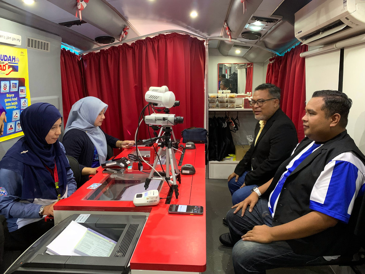 A visitor, Mohd Shahir Khassin, 38 (right), takes the opportunity to renew his identity card at the National Registration Department’s (JPN) Mekar Bus during the 2025 Kelantan MADANI Rakyat (PMR) Programme at the compound of Sultan Muhammad IV Stadium today. – BERNAMA