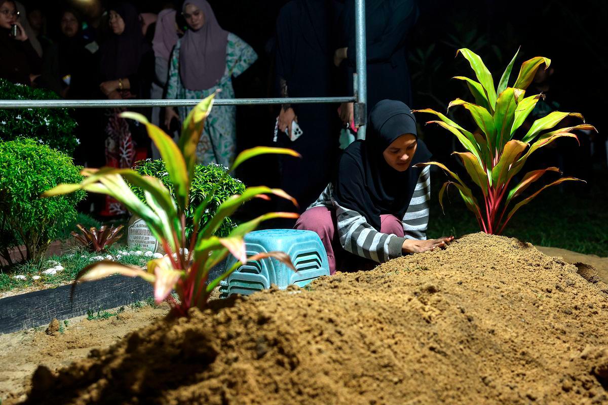 Nur Ayuni Mohd Kamarulzaman, 29, appeared heartbroken after the burial of her son, Muhammad Ammar Muhammad Badrul, 7, who passed away this afternoon after fighting for his life for a week at the Universiti Sains Malaysia Specialist Hospital (HPUSM). He had been assaulted with a hammer by his uncle. The burial took place at the Kampung Mujur Muslim Cemetery, Jelawat, last night. – BERNAMA