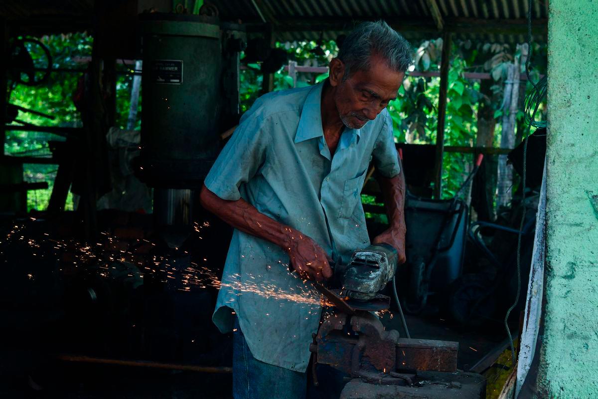Pembuat pisau Fauzi Yusoff, 69, melakukan proses merapikan bilah pisau yang sudah ditempa ketika ditemui Bernama di bengkel pertukangannya di Kampung Hutan Pasir, Ketereh baru-baru ini. FotoBernama