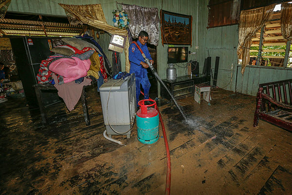 Civil Defence Department (JPA) personnel helps with the cleaning of a flood victim’s home in Kampung Chuchuh Puteri A on Dec 4, 2019 —