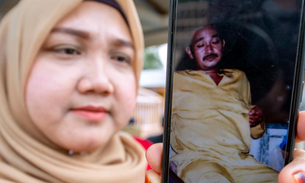Che Wadi’s sister, Cik Normas Bakar, 35 shows a picture of his brother who is still missing in Kuala Kemasin jetty yesterday. — Bernama