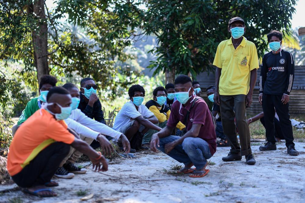 Members of the Batik Orang Asli community wear face masks at their settlement in Kampung Kuala Koh here, following a pneumonia outbreak, during a Bernama survey today. - Bernama