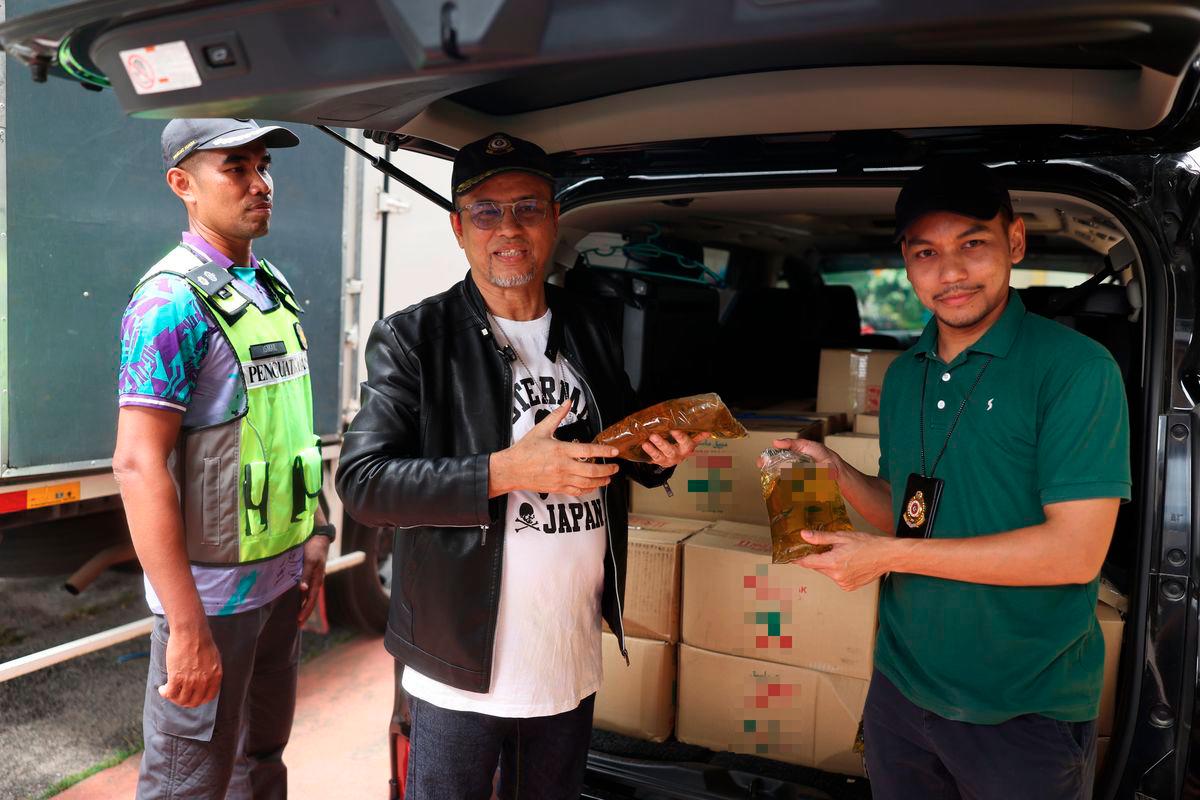 Pengarah Kementerian Perdagangan Dalam Negeri dan Kos Sara Hidup (KPDN) Kelantan Azman Ismail menunjukan antara minyak paket yang dirampas didalam sebuah kenderaan jenis Toyota Vellfire selepas sidang media berkenaan kejayaan KPDN Kelantan menumpaskan sindiket penyeludupan minyak masak bersubsidi dalam satu operasi bersepadu di Pejabat KPDN Kelantan hari ini. - BERNAMA