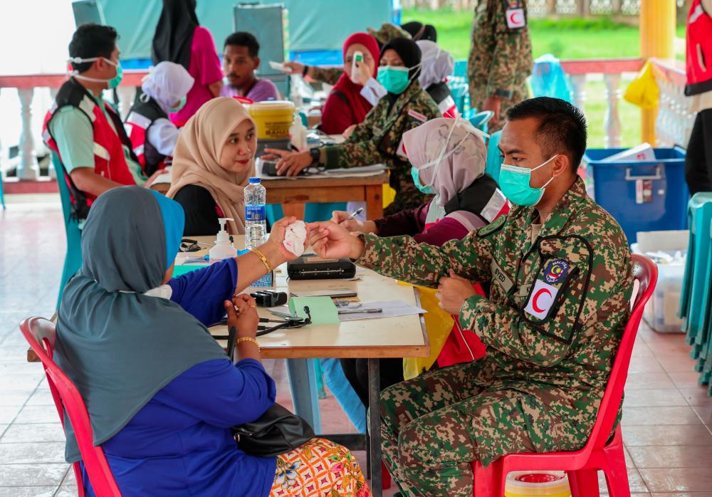 Pasukan Pusat Perubatan Angkatan Tentera Malaysia (ATM) Kem Pengkalan Chepa, 21 Rejimen Askar Melayu Diraja (RAMD) bersama anggota Klinik Kesihatan Kangkong, Pasir Mas membuat pemeriksaan percuma kepada mangsa-mangsa banjir yang ditempatkan di Pusat Pemindahan Sementara (PPS) Sekolah Menengah Kebangsaan Agama (SMKA) Lati di Pasir Mas, Kelantan. - fotoBERNAMA