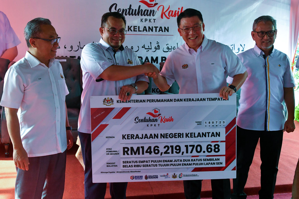 Menteri Perumahan dan Kerajaan Tempatan Nga Kor Ming (dua, kanan) menyampaikan replika cek kepada Exco Kerajaan Tempatan, Perumahan, Kesihatan dan Alam Sekitar Hilmi Abdullah (dua, kiri) pada Program Sentuhan Kasih Kementerian Perumahan dan Kerajaan Tempatan (KPKT) di Kampung Baru Cina hari ini. - BERNAMA