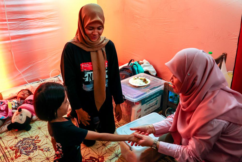 Menteri Pendidikan Fadhlina Sidek menyantuni mangsa banjir yang ditempatkan Pusat Pemindahan Sementara (PPS) Sekolah Kebangsaan Gual Tinggi di Pasir Mas pada Dis 4 2023 - fotoBERNAMA