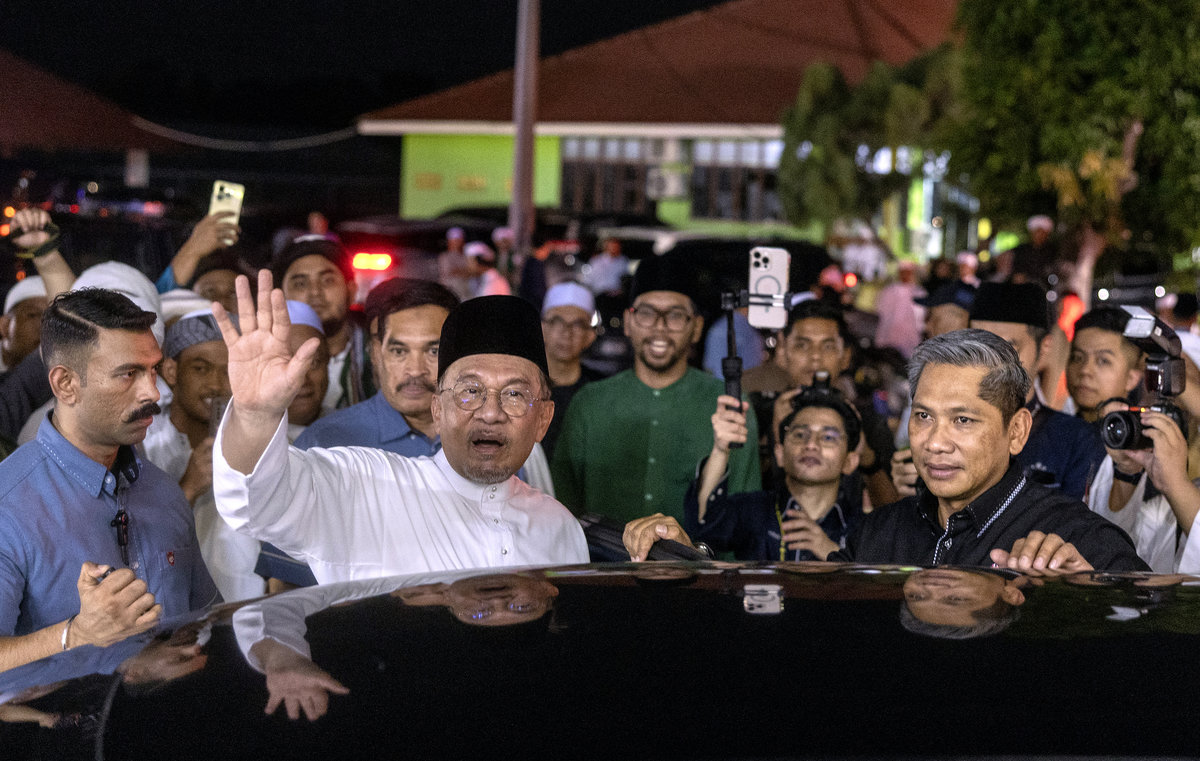 Prime Minister Datuk Seri Anwar Ibrahim waves to the crowd as he departs from the Mahabah MADANI Umara dan Ulama Programme at the Kelantan Islamic Foundation (YIK) Pondok Learning Centre yesterday. – BERNAMA