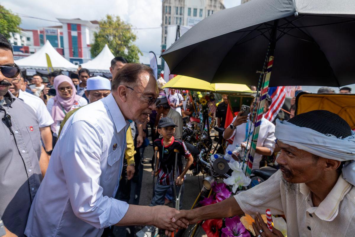 Perdana Menteri Datuk Seri Anwar Ibrahim bersalaman dengan pengayuh beca pada Program MADANI Rakyat (PMR) 2025 Kelantan di perkarangan Stadium Sultan Muhammad IV, hari ini- BERNAMA