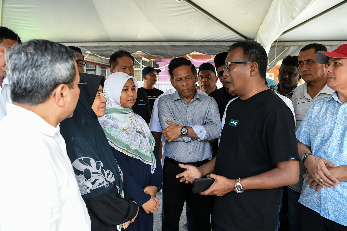 Chairman of the Kedah MADANI Youth Association, Datuk Zuraidi Rahim, speaks with Putri Qisya Nur Izzat, 12, who lost both her parents and four siblings in the tragedy at Sungai Korok last Saturday, during a visit to her relative’s home in Taman Sri Aman here. - BERNAMA