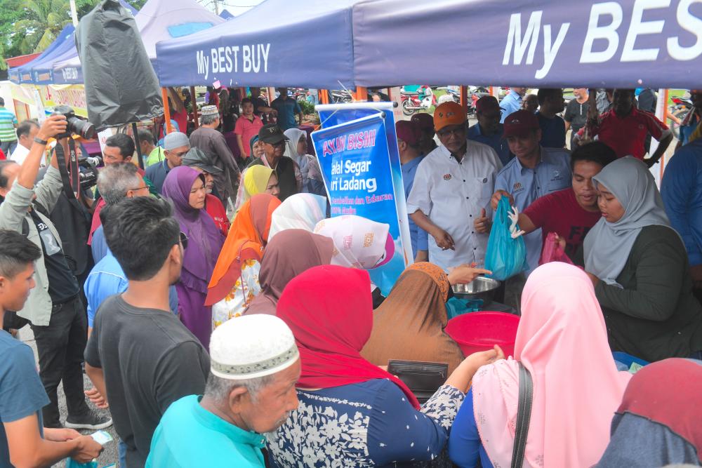 Parti Amanah Negara (Amanah) vice-president Datuk Mahfuz Omar (R4) who is also MP for Pokok Sena look at the sale of chicken meat at the launch of Bazar Peduli Rakyat in Dataran KEDA, Jalan Langgar, Alor Star, Kedah on May 5, 2019. — Bernama