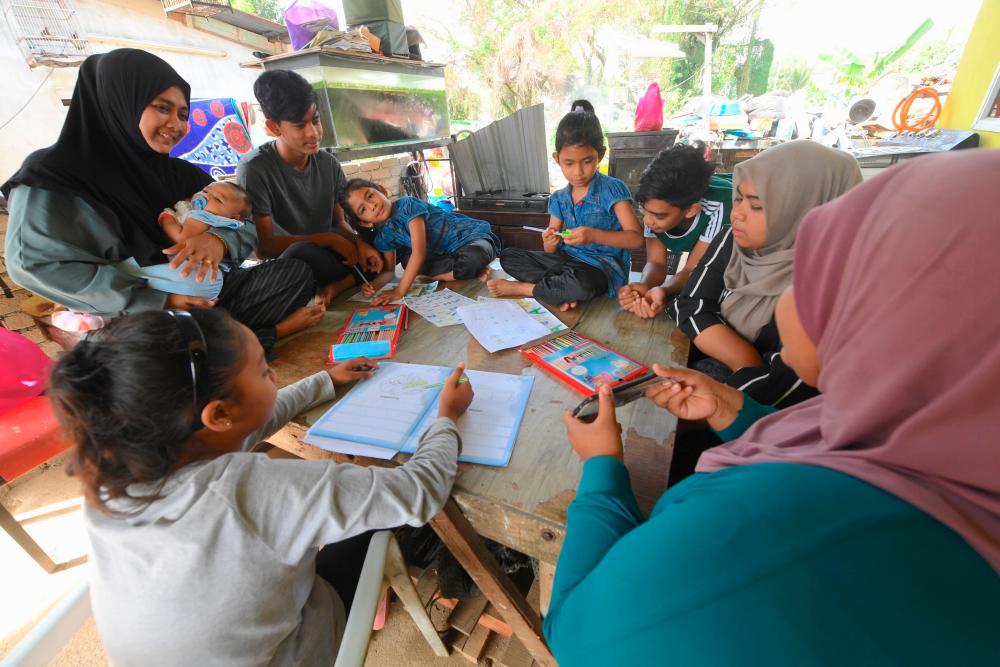 Single mother Saaidah Puteh, 39, (left) from Alor Setar watches as her seven children do their school work using Kaedah Pembelajaran dan Pengajaran di Rumah (PDPR). --fotoBERNAMA (2021) Copyrights Reserved