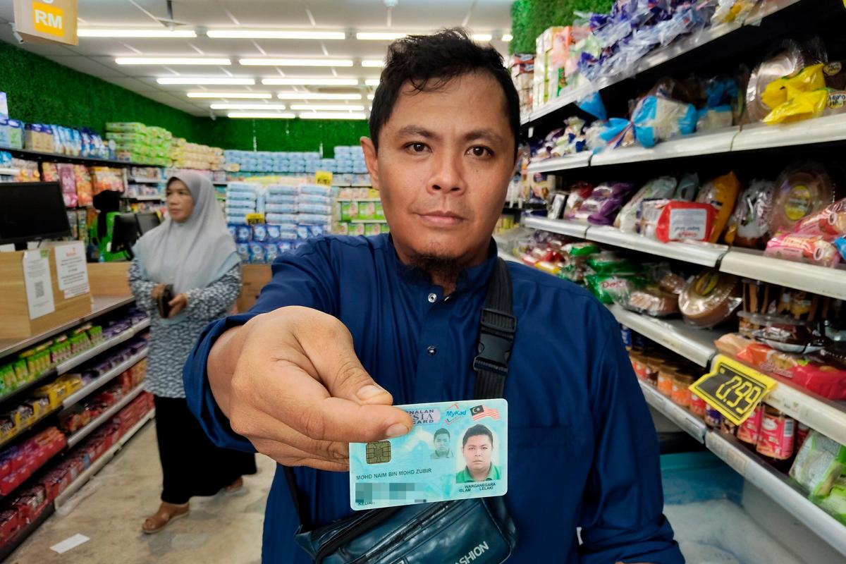 Penerima Sumbangan Asas Rahmah (SARA), Mohd Naim Mohd Zubir, 40, membeli barangan keperluan menggunakan sistem Mykad yang menurutnya ringkas dan tidak timbul karenah ketika pembayaran dan penerimaan baki di sebuah pasaraya hari ini - BERNAMA