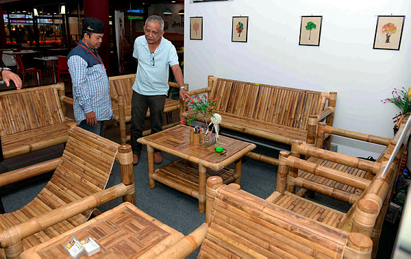 Abdullah Salleh (left) purveys his merchandise made of bamboo to a visitor at the Kedah Wood &amp; Lifestyle Fair 2019 in the Star Parade complex today.