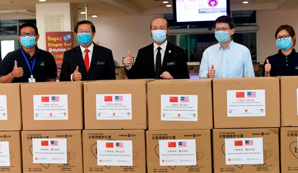 Kedah Mentri Besar Datuk Seri Mukhriz Mahathir receives donation of 15,000 surgical masks from Consulate General of China Lu Shiwei (2R) and 100,000 face masks from XSD International Paper at Wisma Darul Aman today. - Bernama