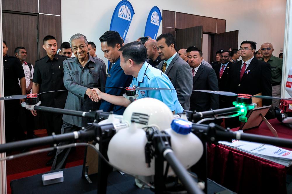 Prime Minister Tun Dr Mahathir Mohamad is greeted by guests at the National Padi Convention, on Sept 10, 2019. — Bernama