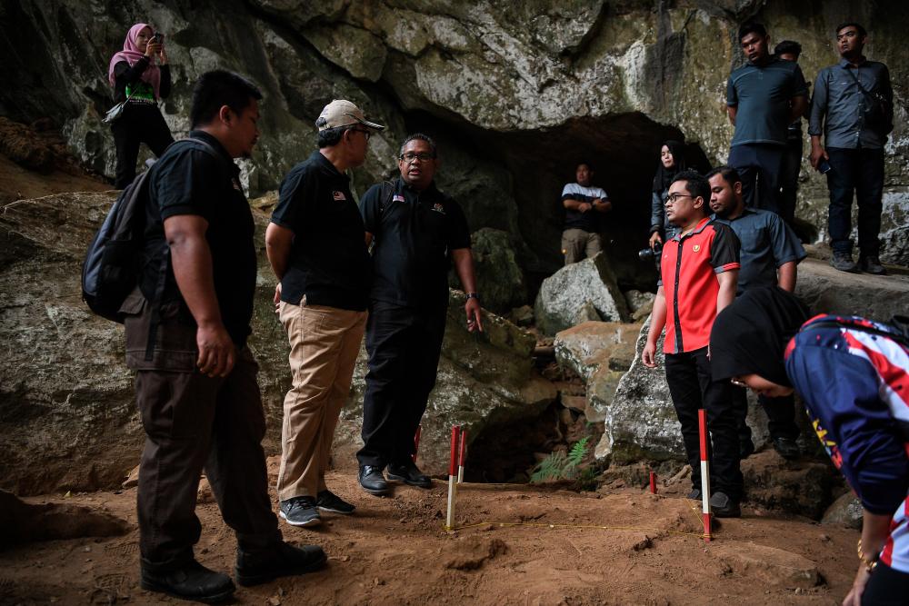 National Heritage Department director Ruzairy Arbi (3rd from L) told National Heritage Department director-general Mesran Mohd Yusop (2nd from L) discuss the discovery of prehistoric artifacts during a visit to Mount Pulai, Baling today. - Bernama