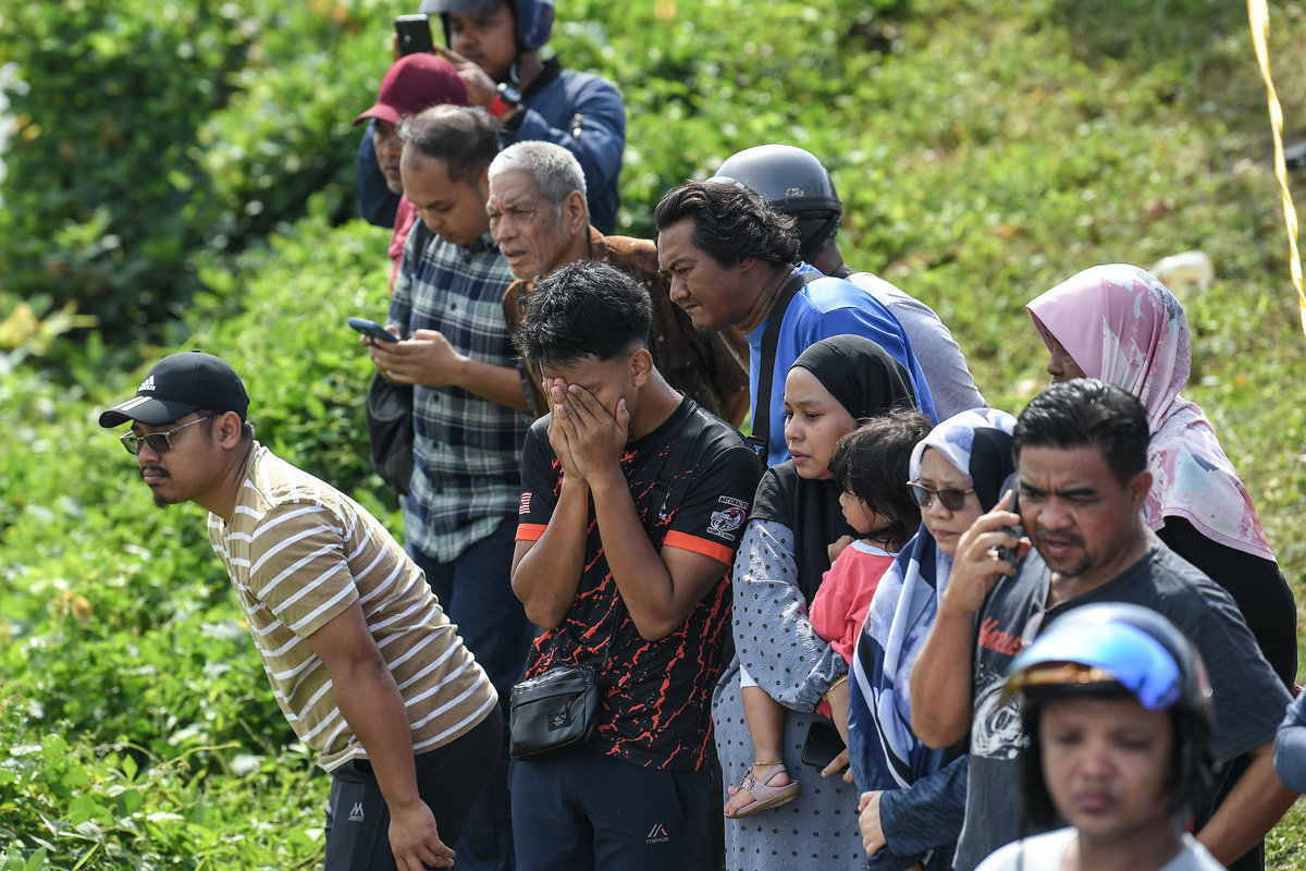 Sebahagian ahli keluarga dan kenalan tidak dapat menahan kesedihan selepas melihat enam mayat yang ditemukan dalam sebuah kereta di dalam Sungai Korok, dekat Jitra hari ini. - BERNAMA