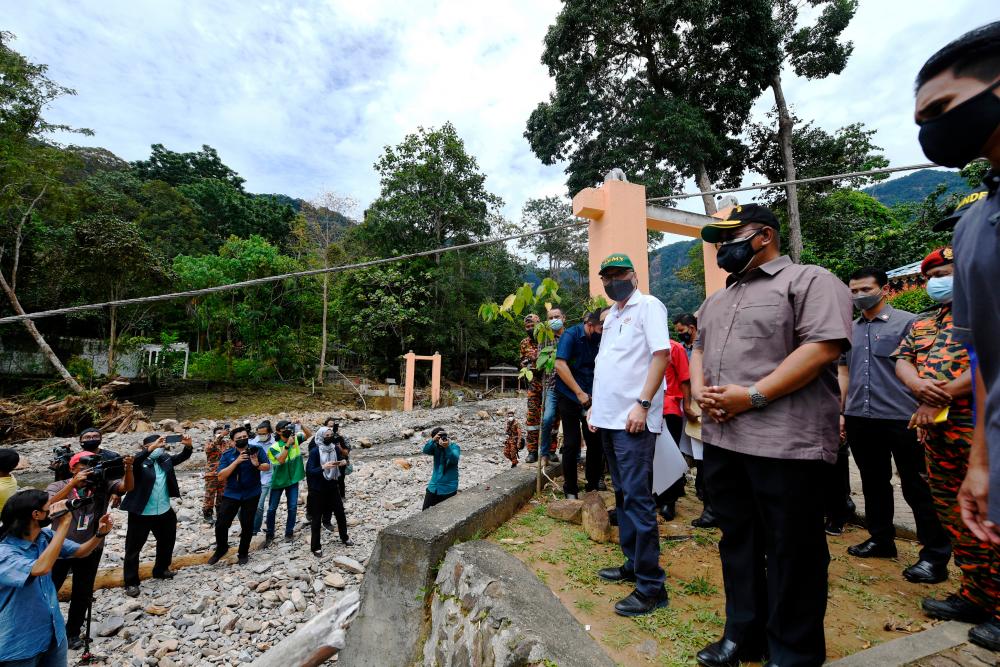 Perdana Menteri Datuk Seri Ismail Sabri Yaakob mengadakan lawatan ke kawasan bencana banjir Titi Hayun Yan pada Ogos 23, 2021. Turut kelihatan Menteri Besar Kedah, Muhammad Sanusi Md Nor.- Bernama