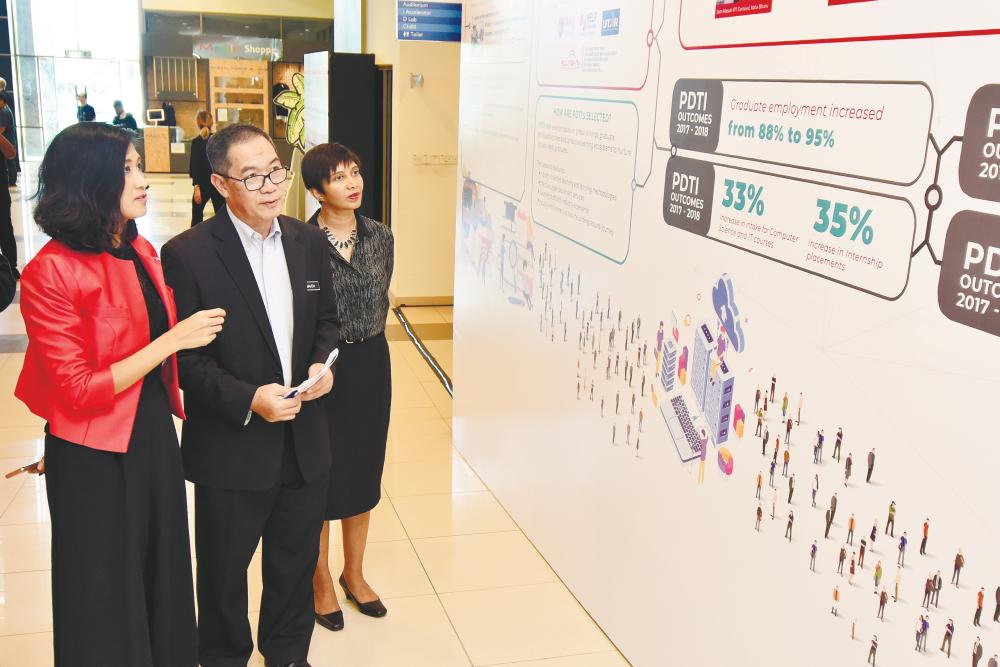 Surina (left) familiarises the Education Ministry’s Higher Education Deputy Director General, Datuk Prof. Ir. Dr. Mohd Saleh Jaafar with the workings of Premier Digital Tech Institutions.