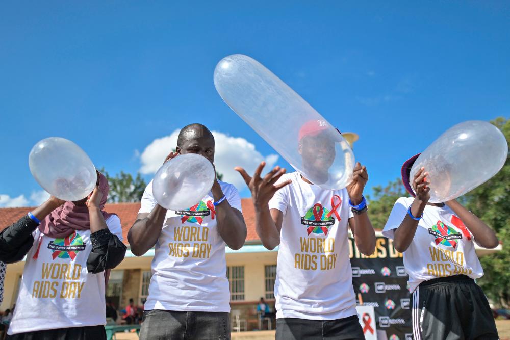 Peer educators compete to inflate condoms during a 'condom olympics' presided over by self declared 'Africa King of Condoms', Stanley Ngara, a kenya national, during a World AIDS Day commemoration at the Kenyatta University campus in Nairobi on December 01, 2021. When Stanley Ngara started teaching young Kenyans about safe sex he found many too embarrassed to listen noting that HIV&amp;AIDS, sex and protection we're taboo subjects in most african homes leading to a surge of infections among the youth who are now the primary target of his outreach as he fights destigmatise safe sexual practice among young people. AFPpix