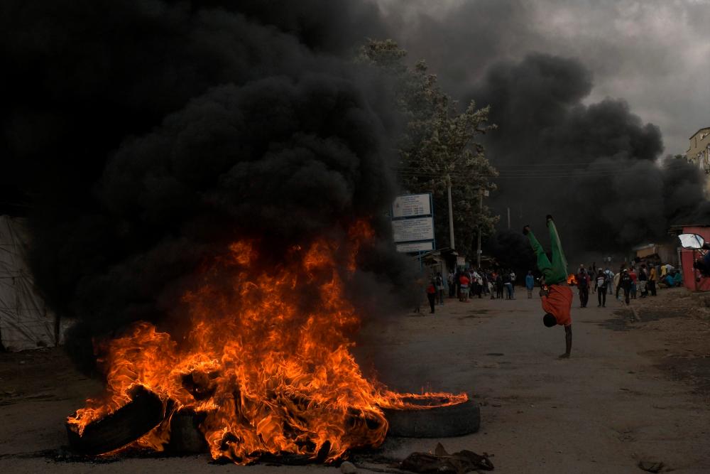 Burning tyres are seen during the mass rally called by the opposition leader Raila Odinga who claims the last Kenyan presidential election was stolen from him and blames the government for the hike of living costs in Kibera, Nairobi on March 20, 2023. AFPPIX
