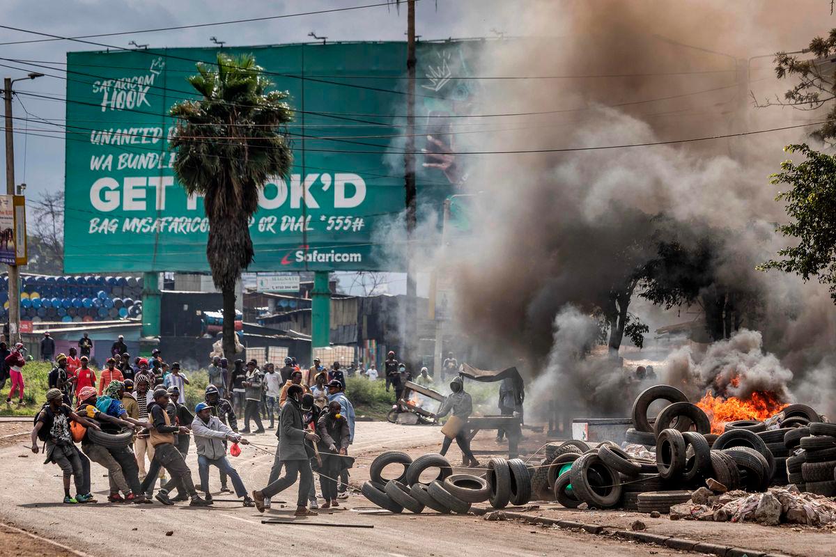 Protesters block a main road with tyres and burning barricades during clashes with Kenya police officers at Saba Saba Day demonstrations in Nairobi on July 7, 2025. (Photo by Luis TATO / AFP)