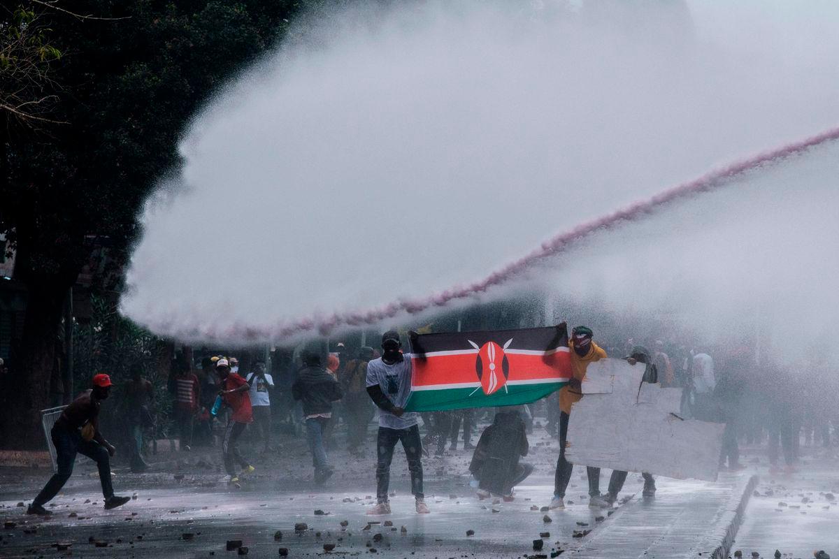 Protesters are caught by the jet of a Kenyan police water cannon in downtown Nairobi on June 25, 2025. (Photo by Kabir Dhanji / AFP)