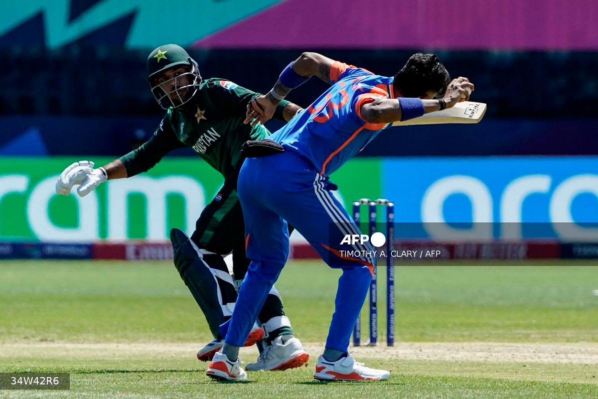India's Hardik Pandya (R) tries to throw the ball past Pakistan's Usman Khan during the ICC men's Twenty20 World Cup 2024 group A cricket match between India and Pakistan at Nassau County International Cricket Stadium in East Meadow, New York on June 9, 2024. - TIMOTHY A. CLARY / AFP