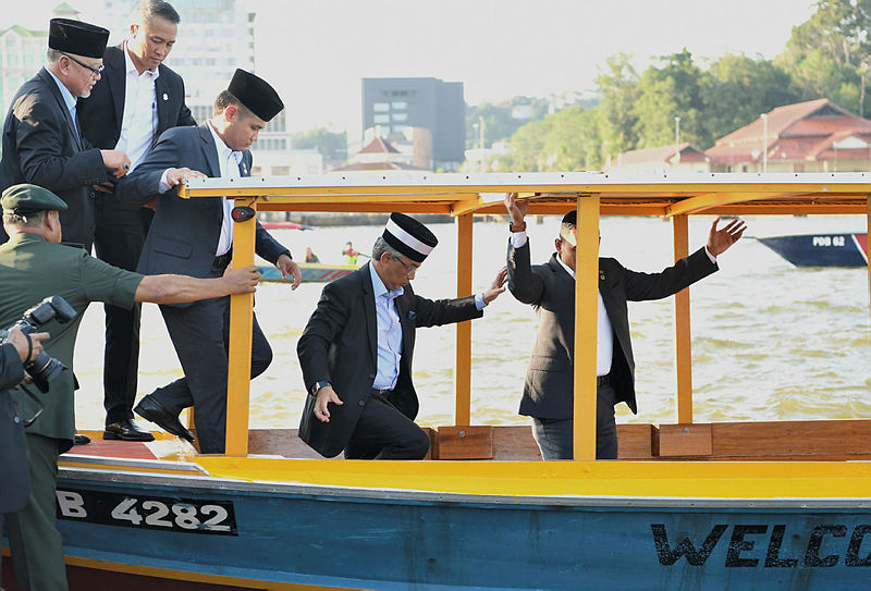 The Yang di-Pertuan Agong Al-Sultan Abdullah Ri’ayatuddin (2nd L) is led into a boat to be taken on a river cruise along the banks of the Brunei River, Kampong Ayer, on Aug 19, 2019. — Bernama