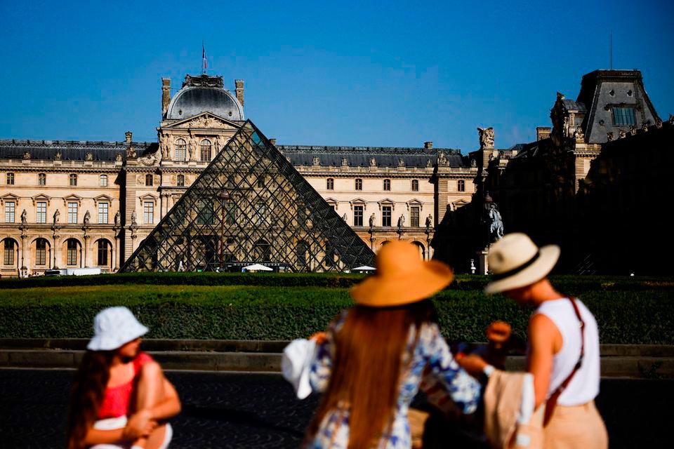 Tourists take a picture in front of the glass Pyramid of the Louvre museum in Paris, France, June 15, 2022. REUTERSPIX