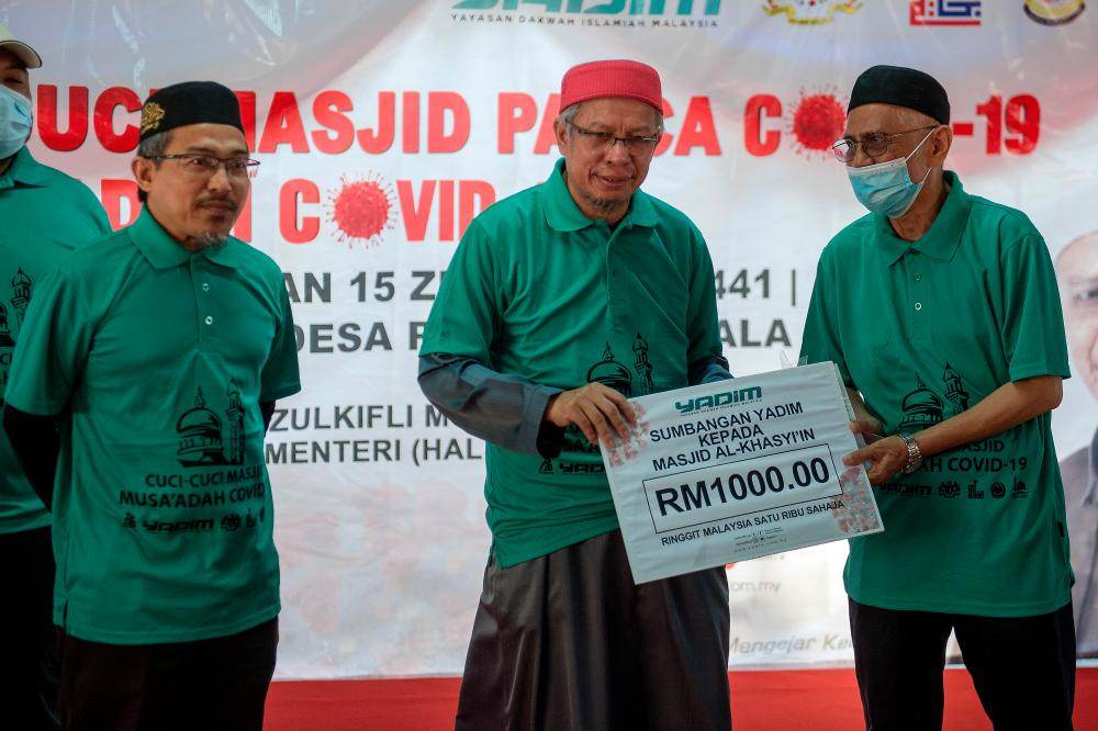 Minister in the Prime Minister’s Department (Religious Affairs) Datuk Seri Dr Zulkifli Mohamad Al-Bakri (C) presents a replica checque to Al-Khasyi’in Mosque Chairman Mustapha Abdullah (R) during the presentation of Covid-19 Musaadah Fund held at Desa Petaling today. - Bernama