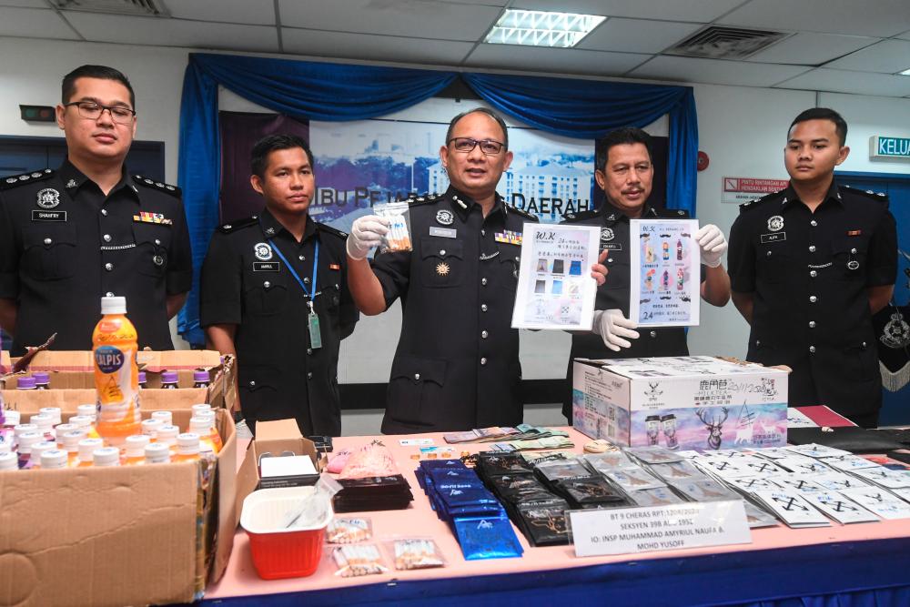 Cheras district police chief ACP Mohamed Mokhsein Mohamed Zone (c) displays the more than RM788,000 worth of pills, powders, ecstasy and marijuana seized following the arrest of two local men and a foreign woman, at a press conference at the Cheras district police headquarters today. - Bernama