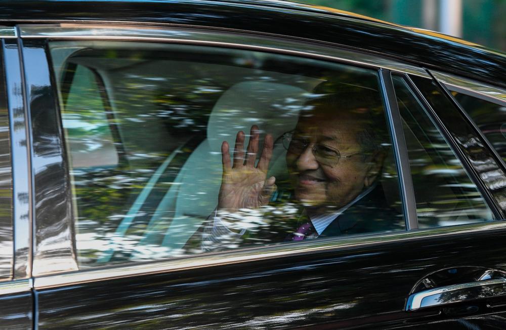 Interim Prime Minister Tun Dr Mahathir Mohamad waves to the media as he leaves his private residence in Seri Kembangan, on Feb 27, 2020. — Bernama