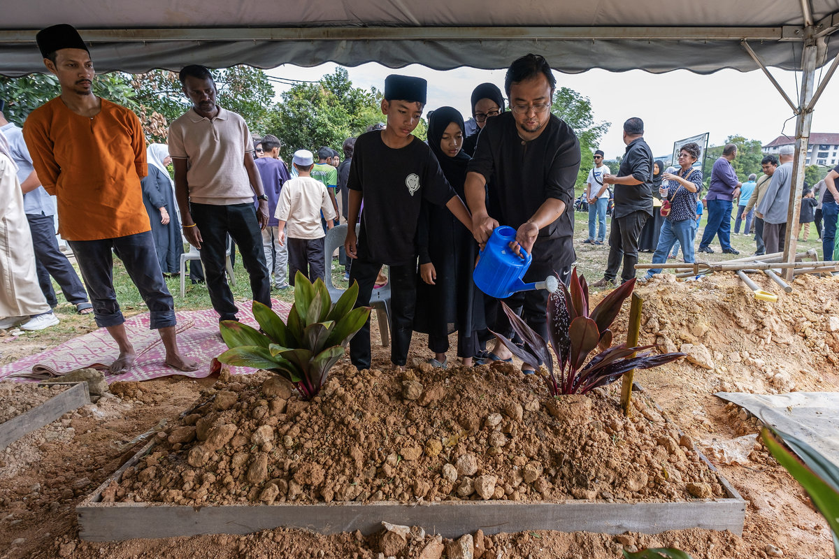 Family members poured water on the grave of Muhammad Khairy Nunis Abdullah, also known as Kevin Christopher Nunis, after he was laid to rest at the Taman Sri Sinar Segambut Muslim Cemetery today. - BERNAMA