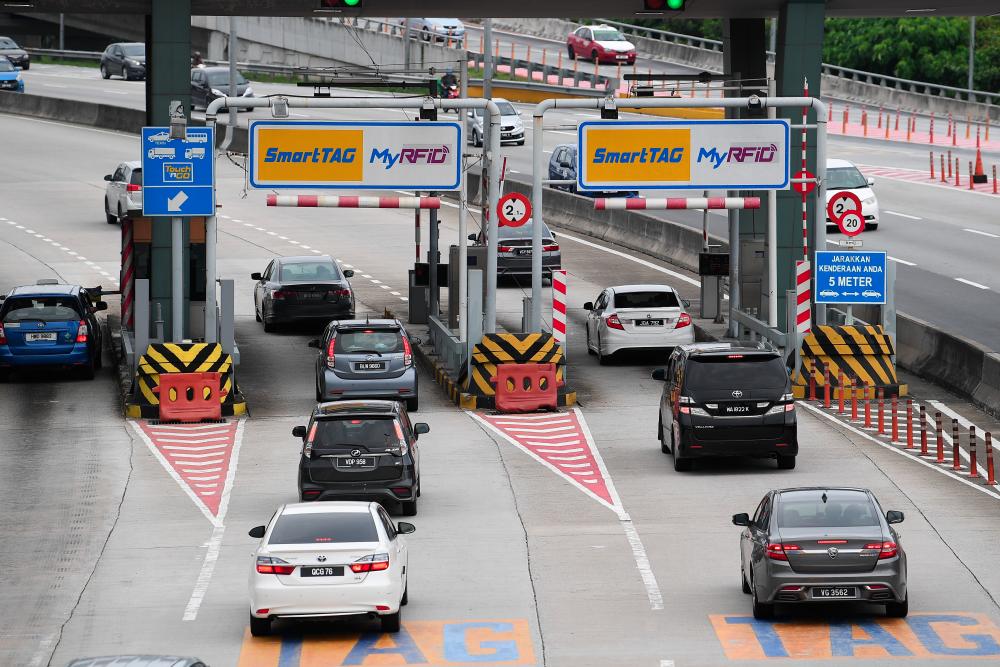 Road users using Touch ‘n Go Radio Frequency Identification (RFID) technology in Duke Highway recently. — Bernama