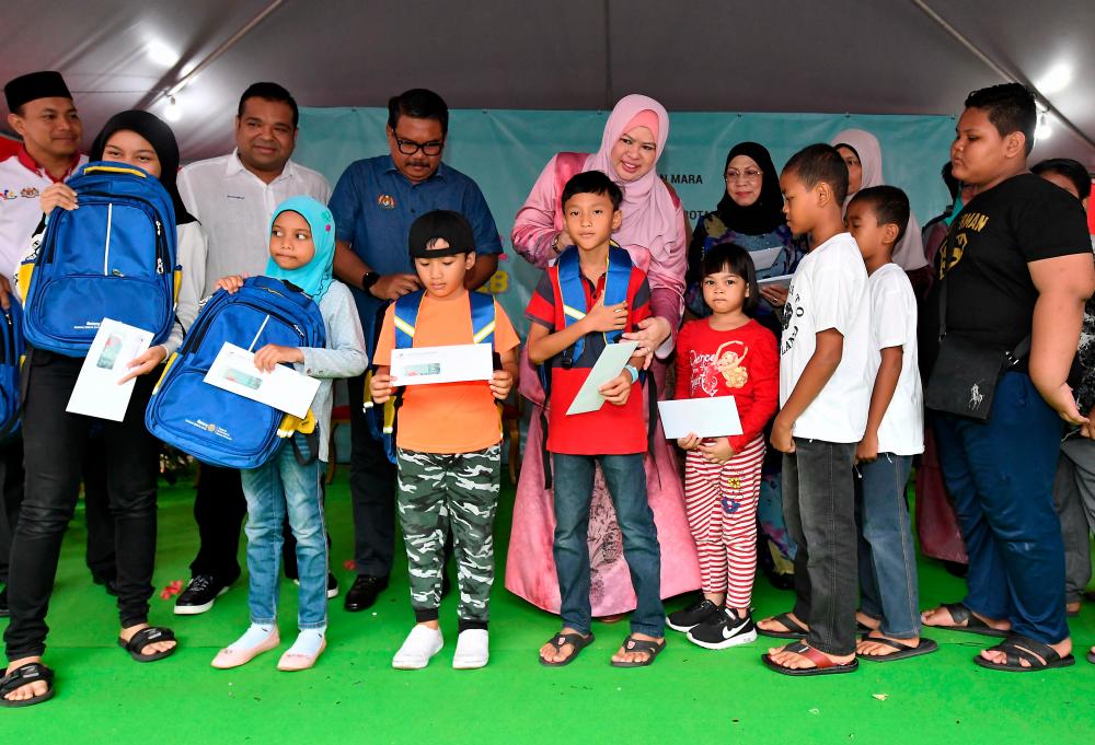 Rural Development Minister Datuk Seri Rina Mohd Harun (C) presents school bags and other types of assistance to recipients at the Titiwangsa Parliamentary Back to School 2020 programme @KPLB today. - Bernama