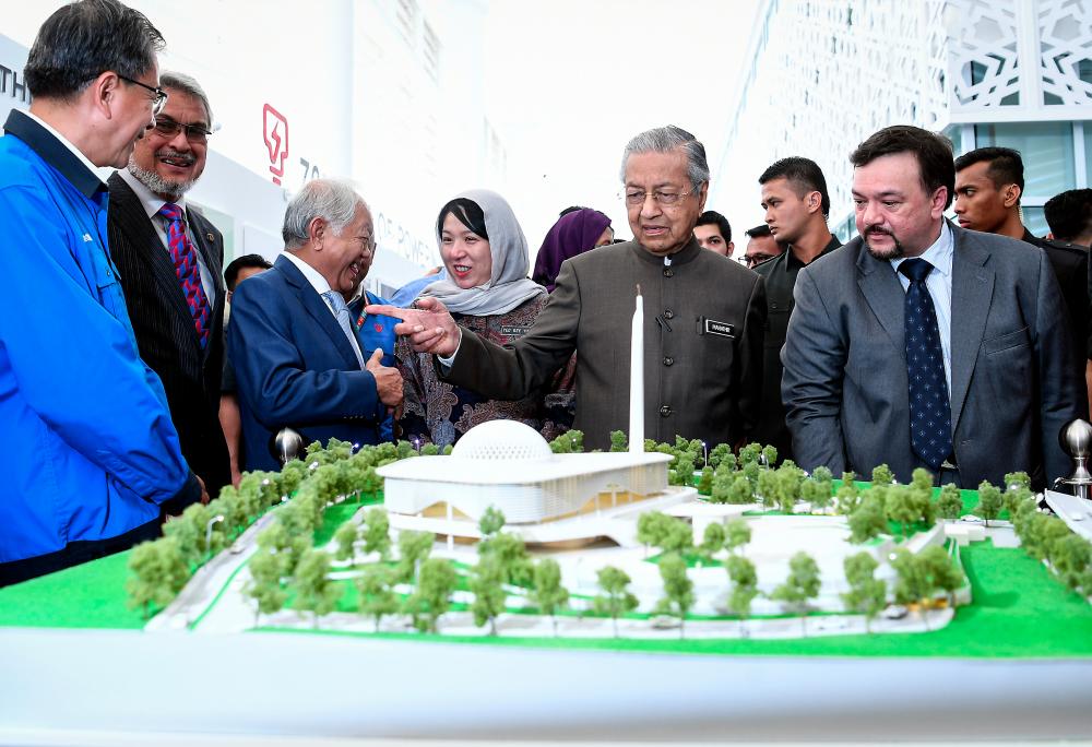 Prime Minister Tun Dr Mahathir Mohamad looks at the replica of Tenaga Nasional Berhad (TNB)’s An-Nur Balai Islam Complex at the TNB new headquarters on 16 Jan. — Bernama