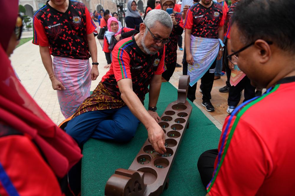 Federal Territories Minister, Khalid Abdul Samad participates in a congkak game during the Malaysia Games Festival @ Kuala Lumpur at Dataran Merdeka, on Sept 15, 2019. — Bernama