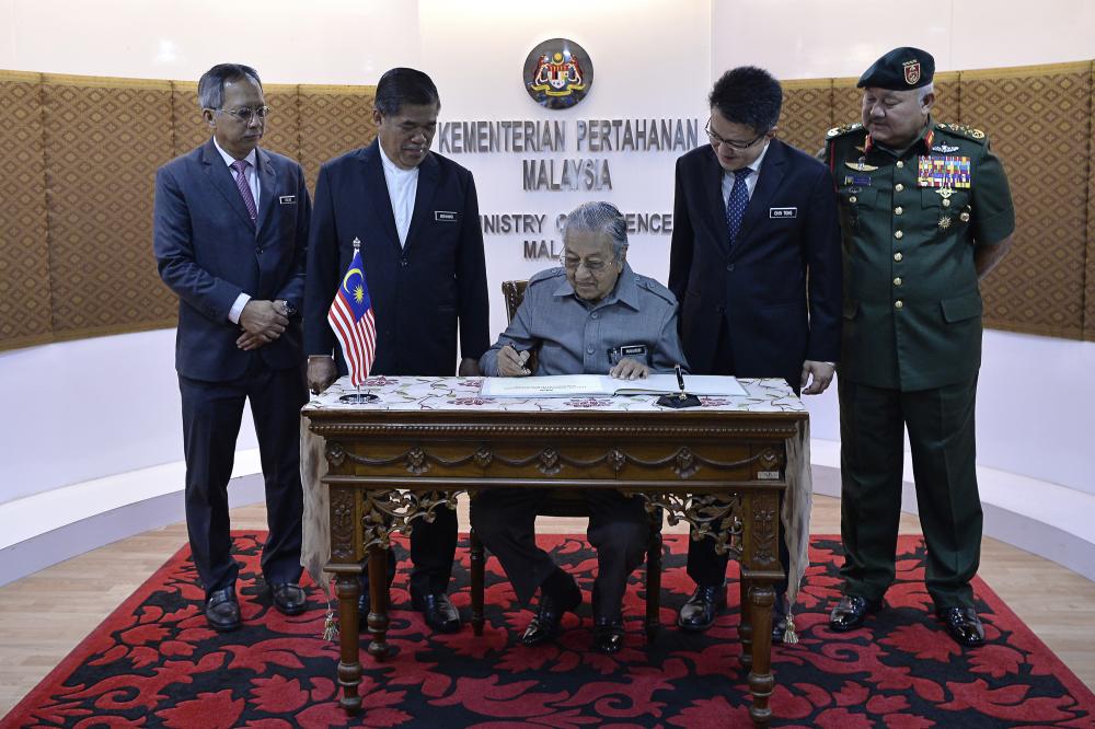 Prime Minister Tun Dr Mahathir Mohamad signs a guest book during an official visit to the Ministry of Defense at Wisma Pertahanan, on Feb 21, 2019. — Bernama