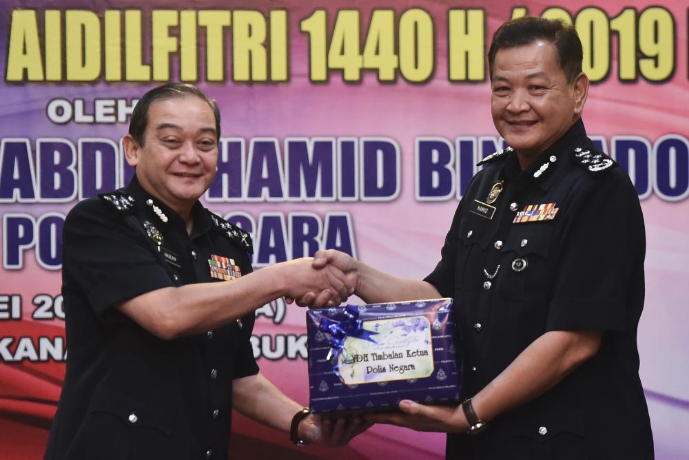 IGP Datuk Seri Abdul Hamid Bador (R) hands over a parcel to his deputy Datuk Mazlan Mansor at the Senior Officers Mess in Bukit Aman on May 28, 2019. - Bernama