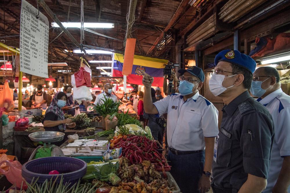 KPDNHEP secretary-general Datuk Seri Hasnol Zam Zam Ahmad reviews the sale price during an inspection operation in conjunction with the implementation of the price control scheme at the Keramat Market today. - Bernama