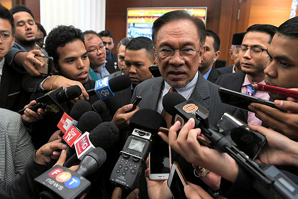PKR president Datuk Seri Anwar Ibrahim speaks to reporters in the Parliament lobby today. - Bernama