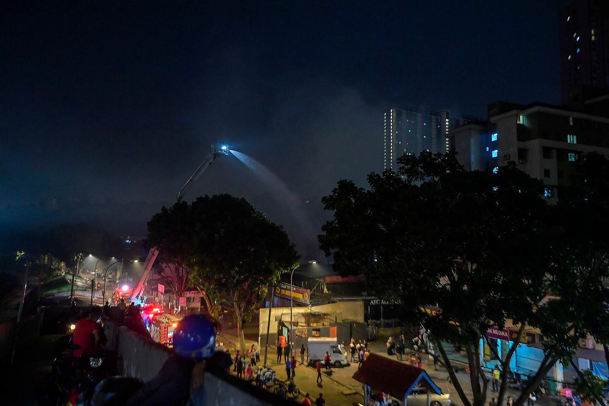 Anggota Jabatan Bomba dan Penyelamat Malaysia (JBPM) giat memadamkan sisa kebakaran yang menyebabkan beberapa buah lot kedai dan rumah di Pantai Dalam, Kuala Lumpur terbakar dalam kejadian malam tadi. - fotoBERNAMA