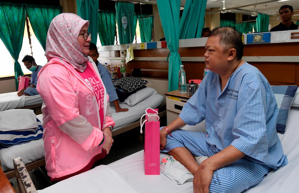 The Raja Permaisuri Agong Tunku Hajah Azizah Aminah Maimunah Iskandariah speaks to a patient at the Radiotherapy and Oncology ward of the Kuala Lumpur Hospital, on Oct 19, 2019. — Bernama