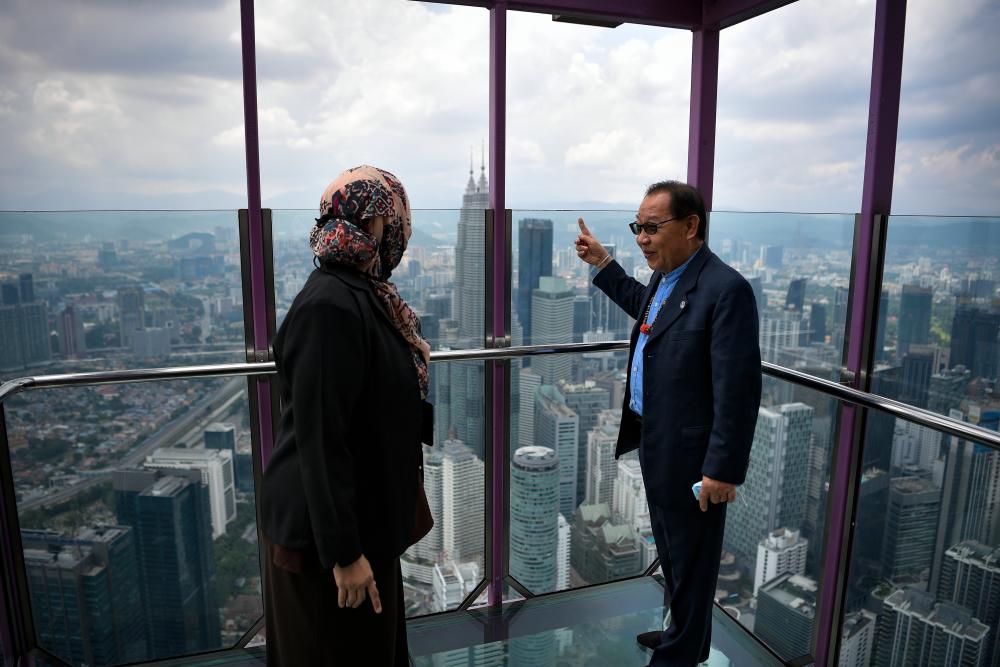 Deputy Tourism, Arts and Culture Minister Datuk Dr Jeffrey G. Kitingan (R) and Kuala Lumpur Tower Sdn Bhd CEO Ainol Shaharina Sahar (L) observed the view of the capital from the ‘Sky Deck’ cabin during the ‘We Are Free’ promotion at the Kuala Tower Tower today. - Bernama
