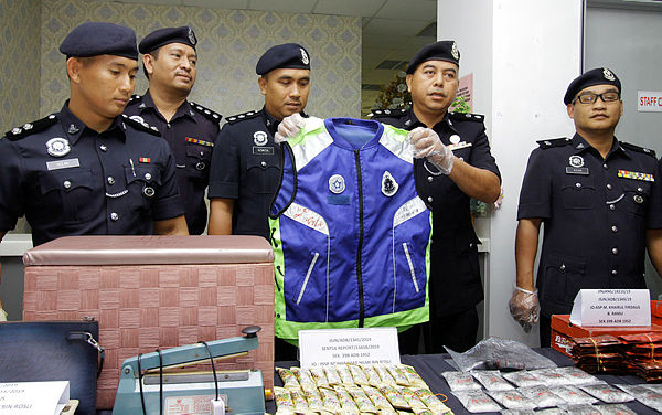 Sentul deputy police chief Supt Heisham Harun (2nd from R) and other police officers display the items seized from a drug syndicate during a press conference at Sentul district police headquarters today. — Bernama