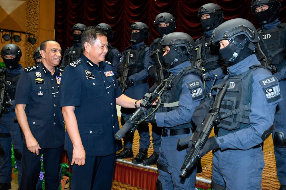 IGP Tan Sri Abdul Hamid Bador and Bukit Aman NCID director Datuk Khalil Kader Mohd (2nd from L) have a friendly chat with NCID members during the launch of the departments corporate video and theme song at the Police Officers’ College in Cheras today. - Bernama