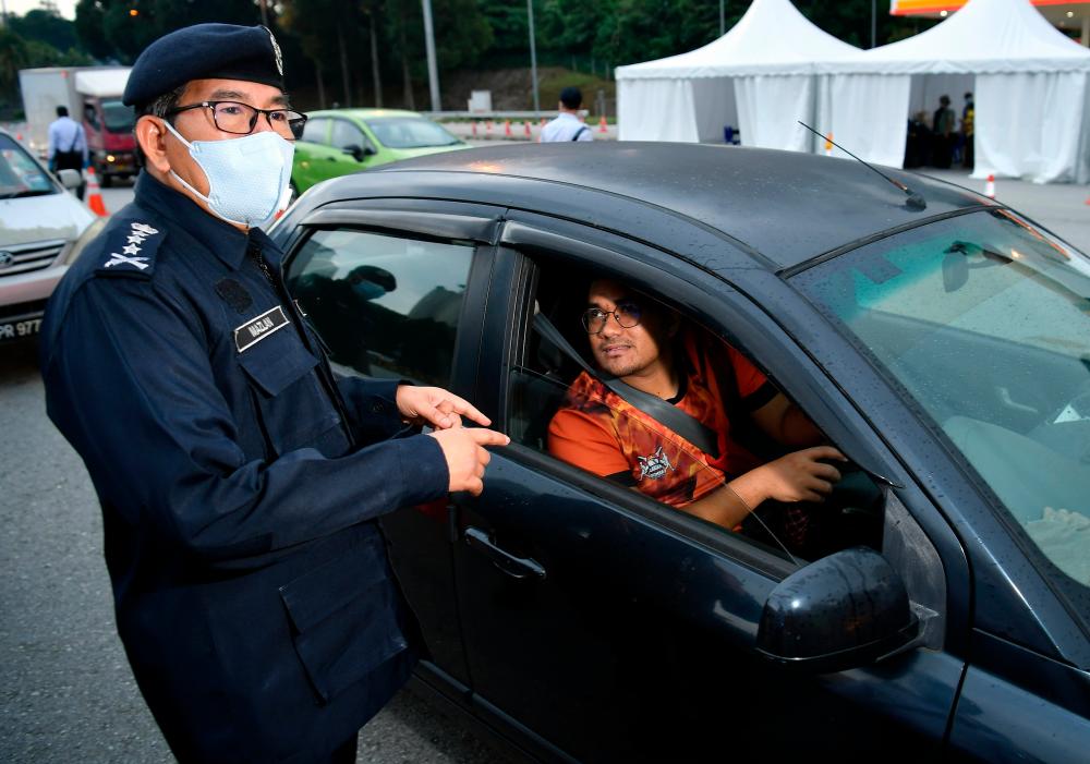 Kuala Lumpur police chief Datuk Seri Mazlan Lazim checks with a car driver during a visit at a roadblock near the Jalan Duta Toll Plaza heading to Kuala Lumpur today. - Bernama