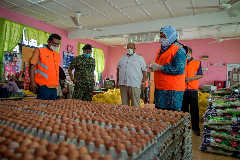 Women, Family and Community Development Minister Datuk Seri Rina Mohd Harun (R) looks at eggs to be distributed to recipients during a survey at a food collection centre in Gombak today. - Bernama
